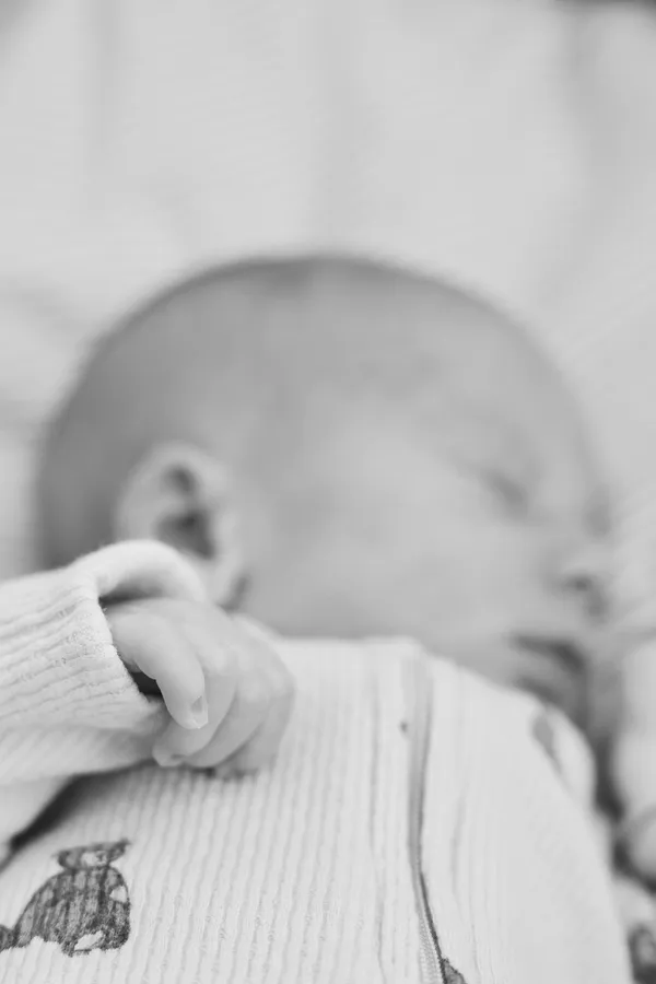 Close-up of a newborn's tiny hand, soft black and white photograph